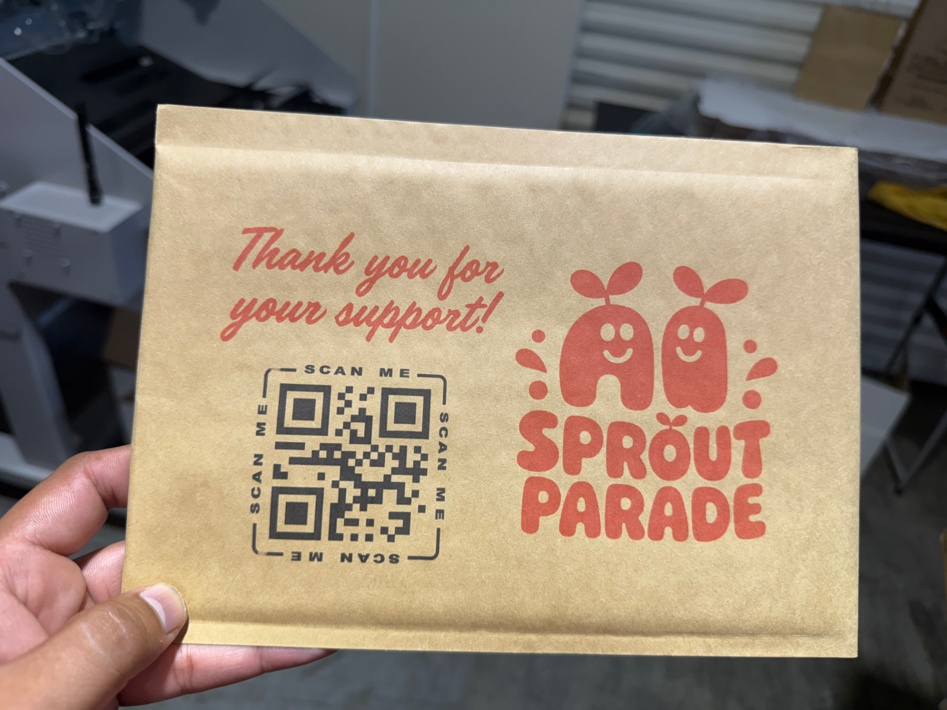 Kraft padded mailer printed with a playful logo, thank-you message and QR code
