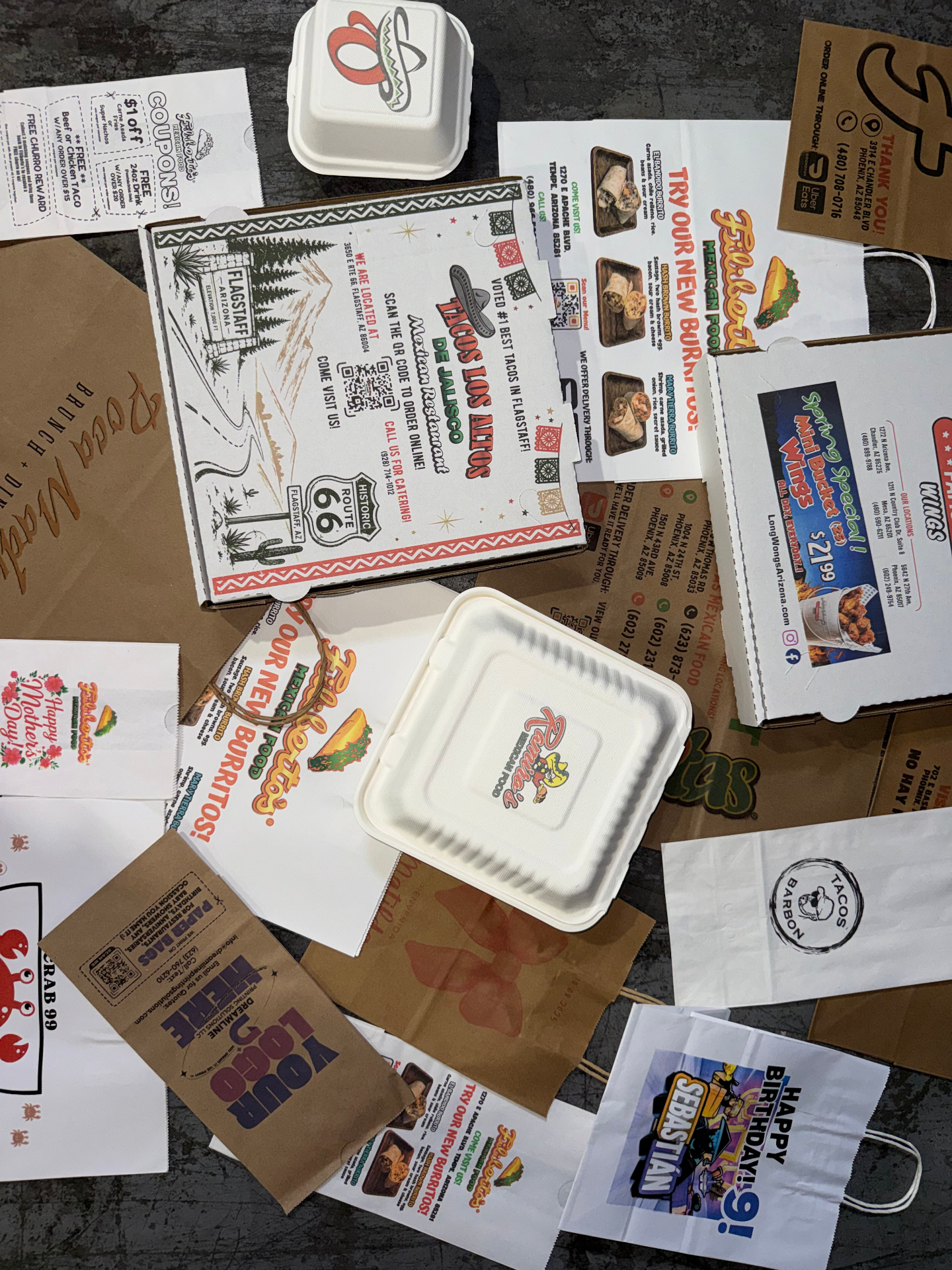 Real Dreamline custom-printed packaging including pizza boxes, takeout bags, food containers, and event bags