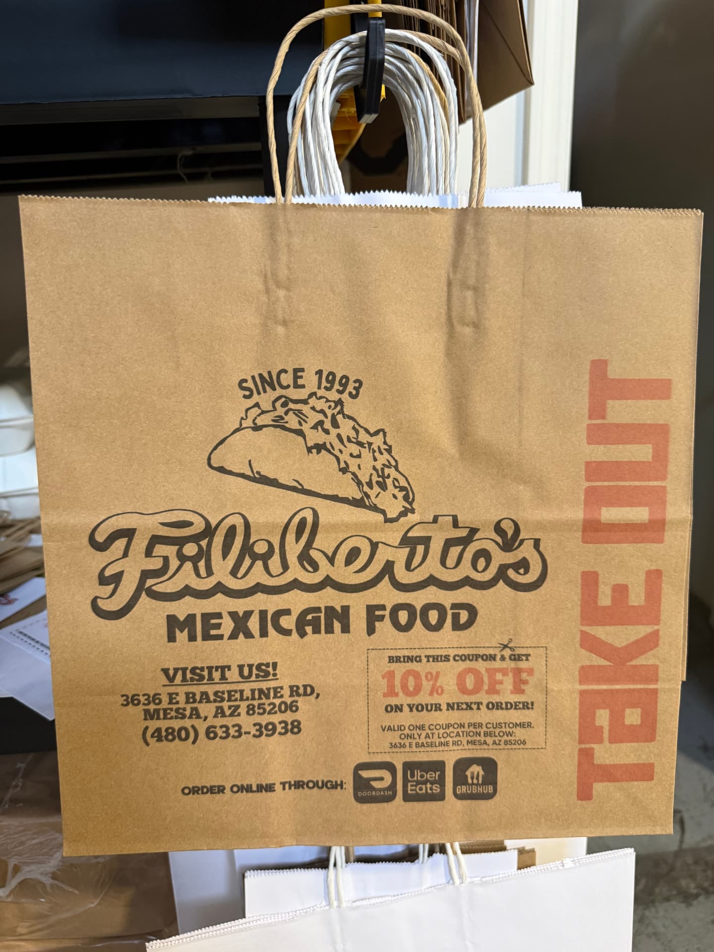 Custom printed kraft takeout paper bag with handles printed with a restaurant logo and coupon