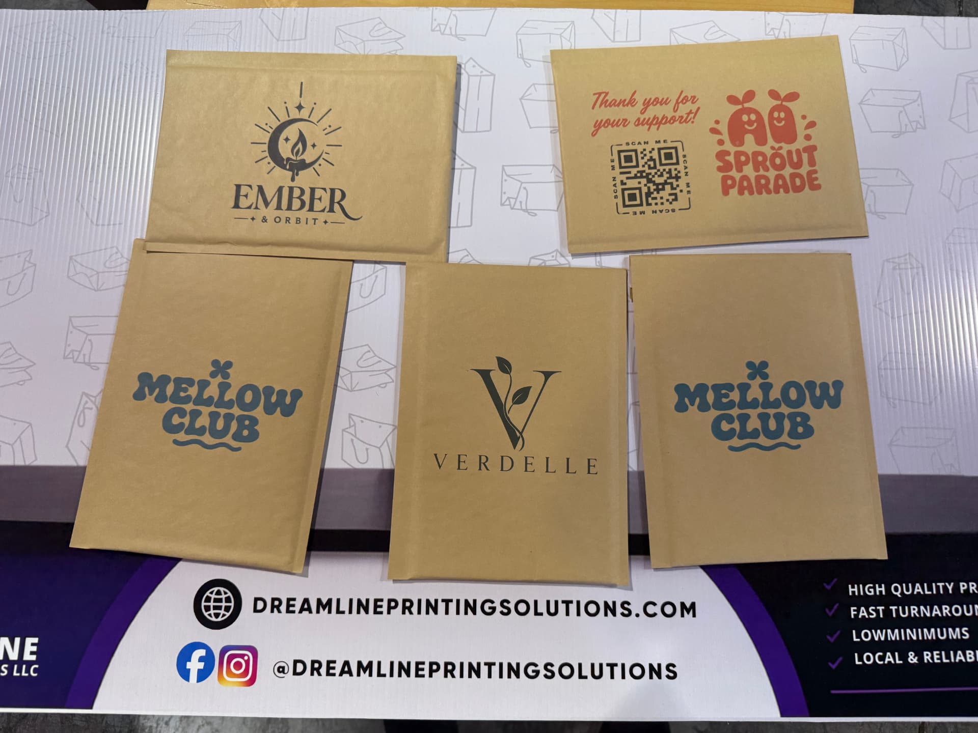 Five kraft padded mailers printed with different small business logos