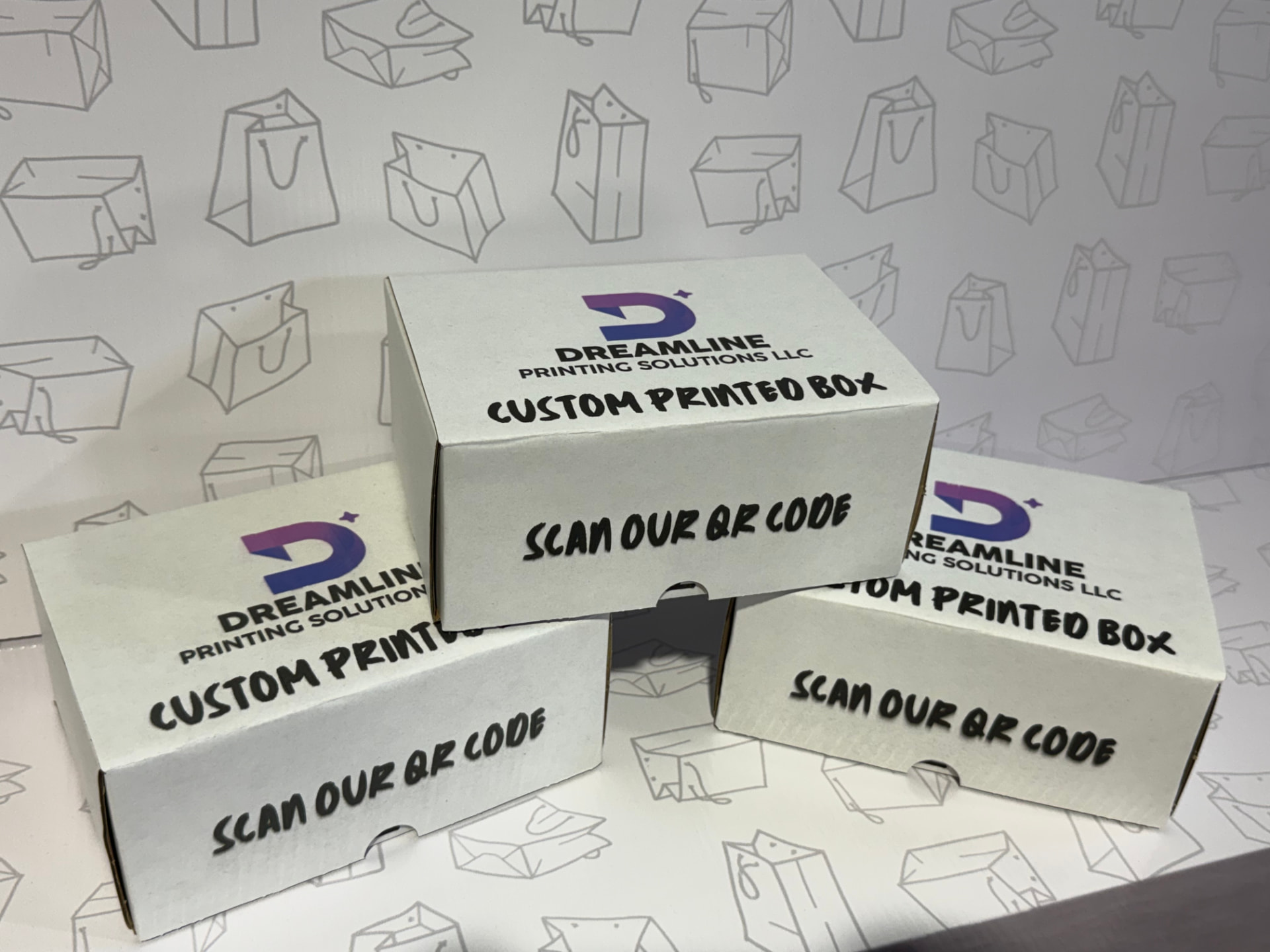 Three white custom printed mailer boxes with the Dreamline logo and QR code message