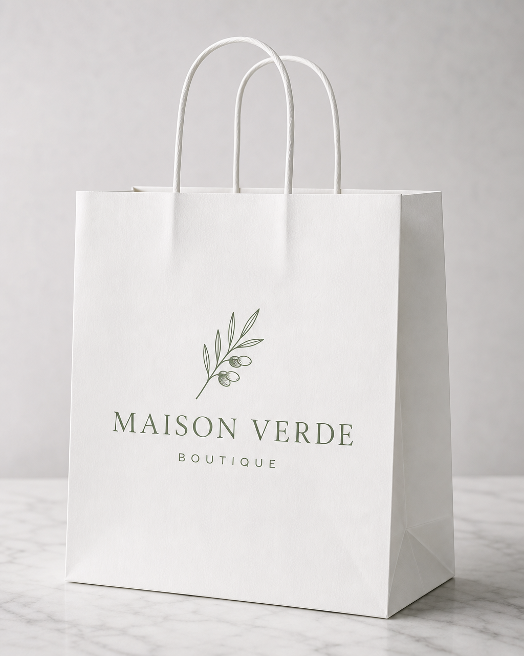 White paper shopping bag with twisted white handles printed with a boutique logo